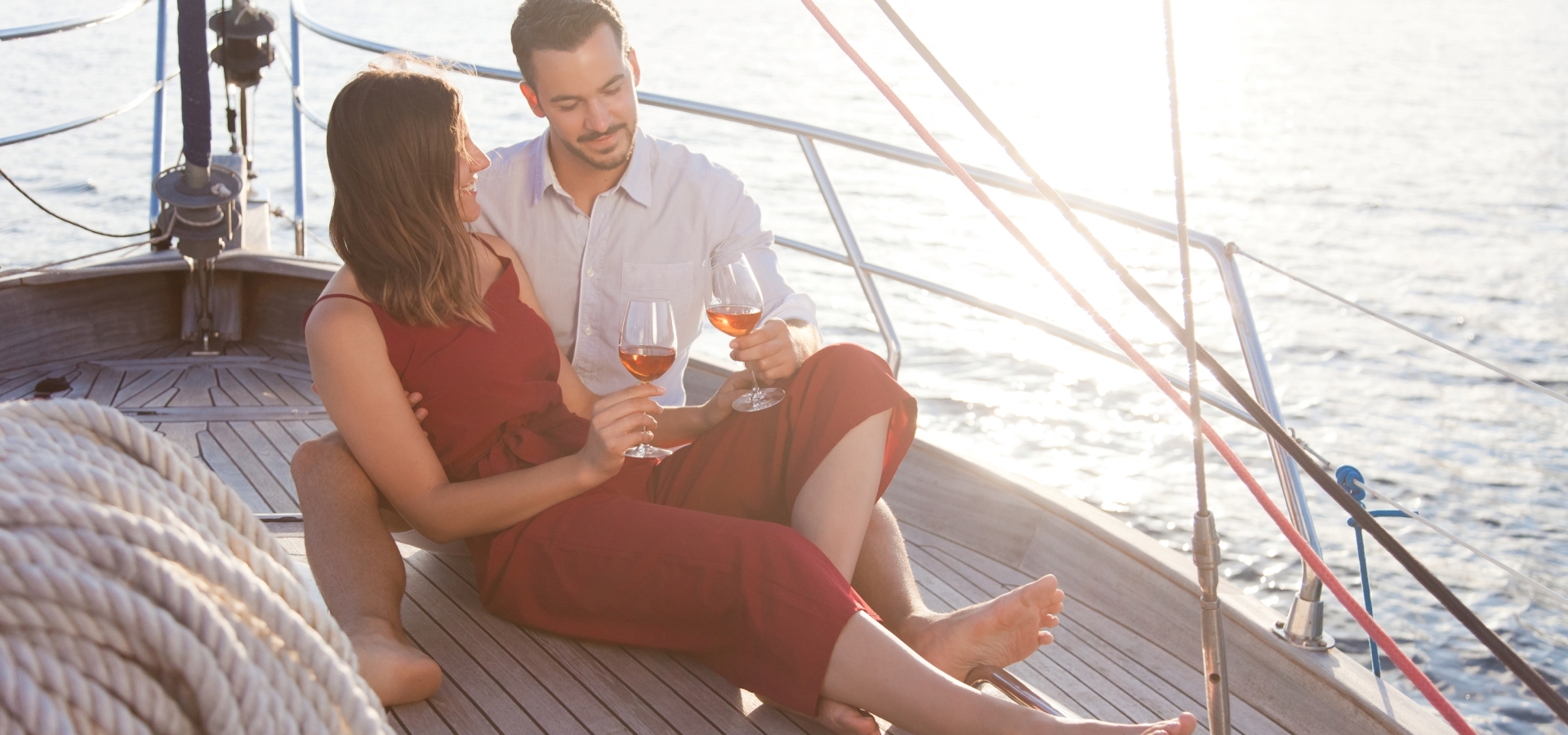 A couple enjoying a glass of wine while sailing on the lake.