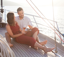 A couple enjoying a glass of wine while sailing on the lake.