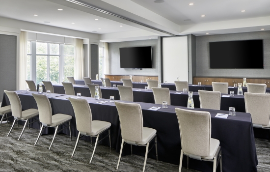 meeting room with built-in monitors and windows with natural lighting