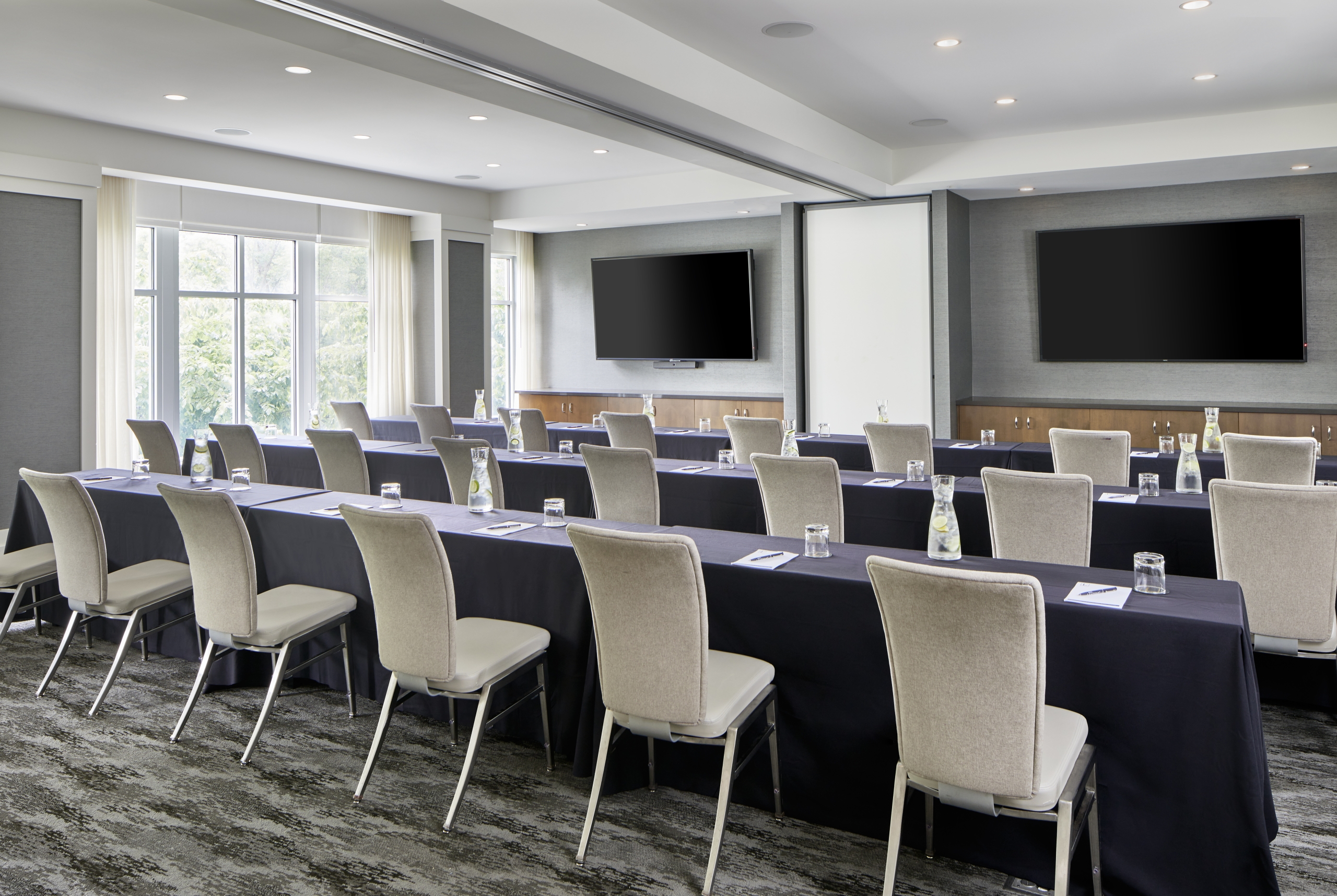meeting room with built-in monitors and windows with natural lighting