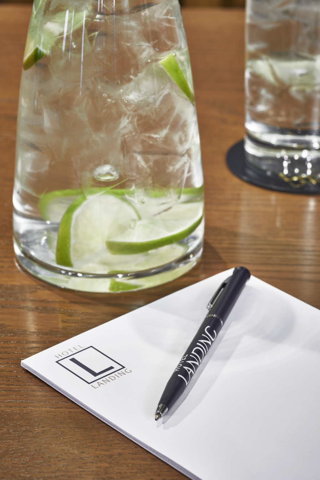 boardroom showing glass of water with pen and paper