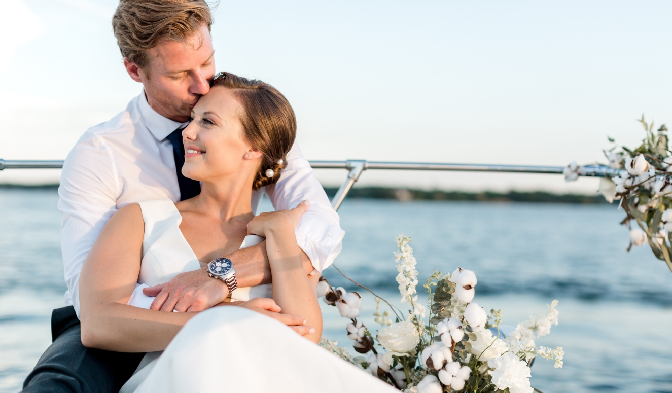 groom holding bride on boat