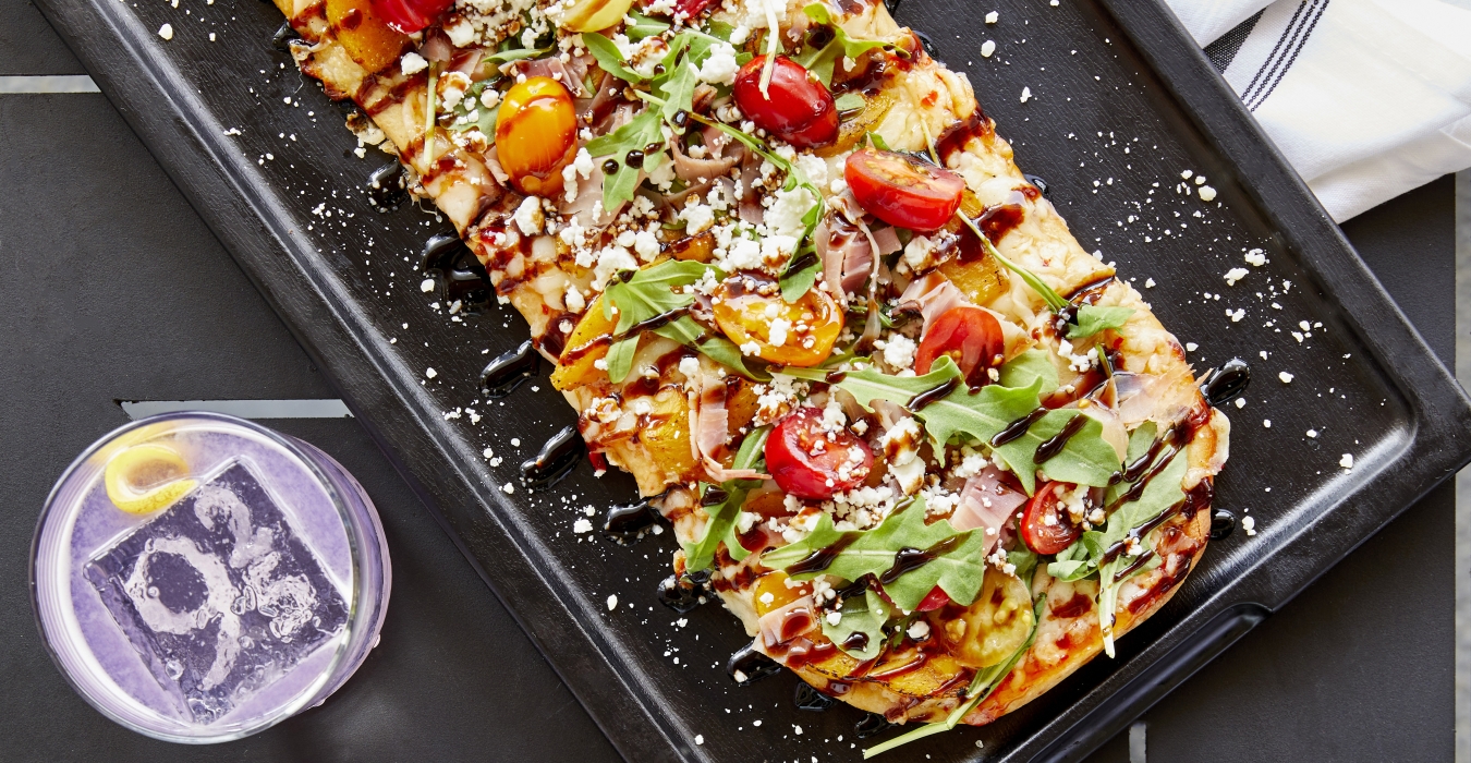 Flatbread pizza and cocktail set on dinner table