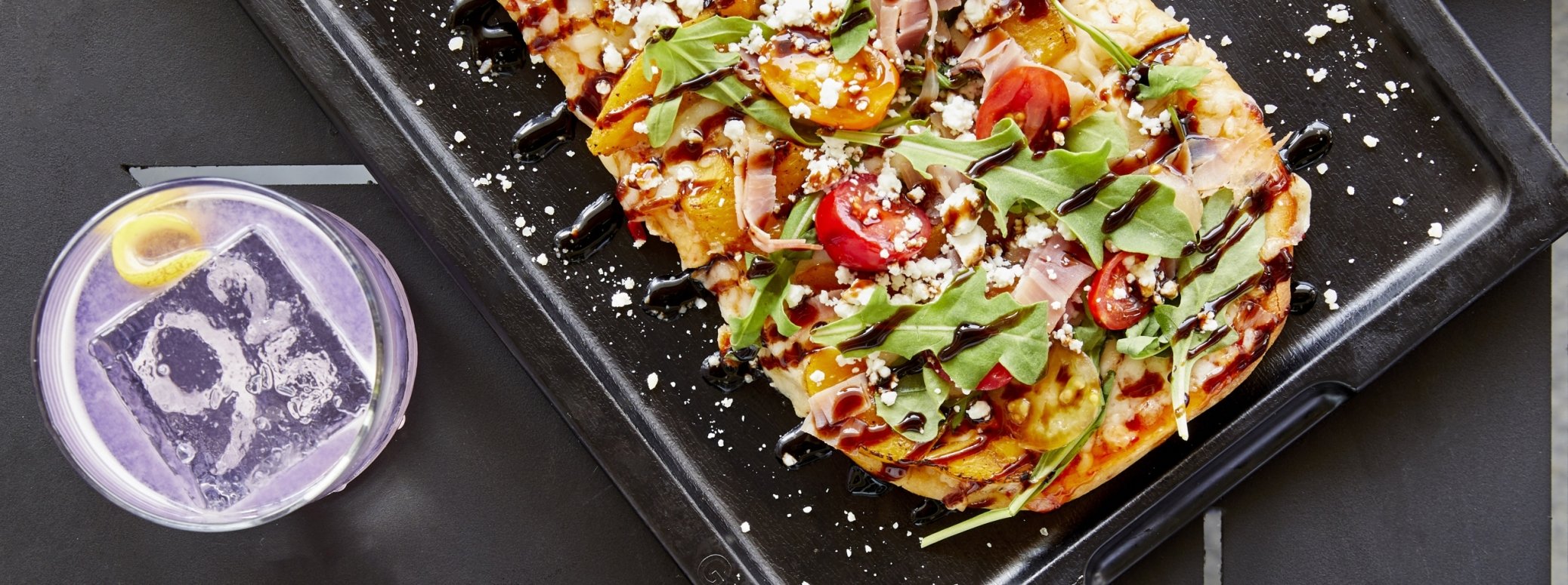 Flatbread pizza and cocktail set on dinner table
