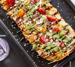Flatbread pizza and cocktail set on dinner table