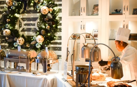 A chef at a holiday buffet carving station.