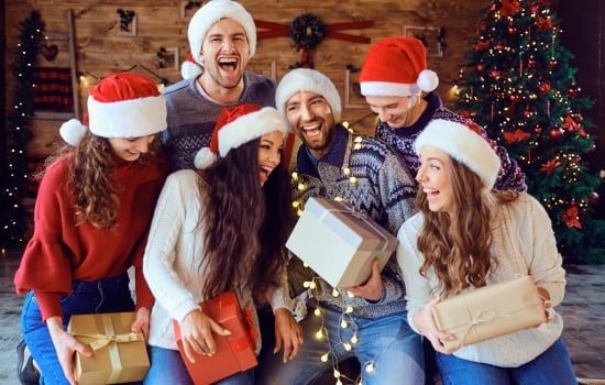 Happy friends with gifts celebrating the holidays.