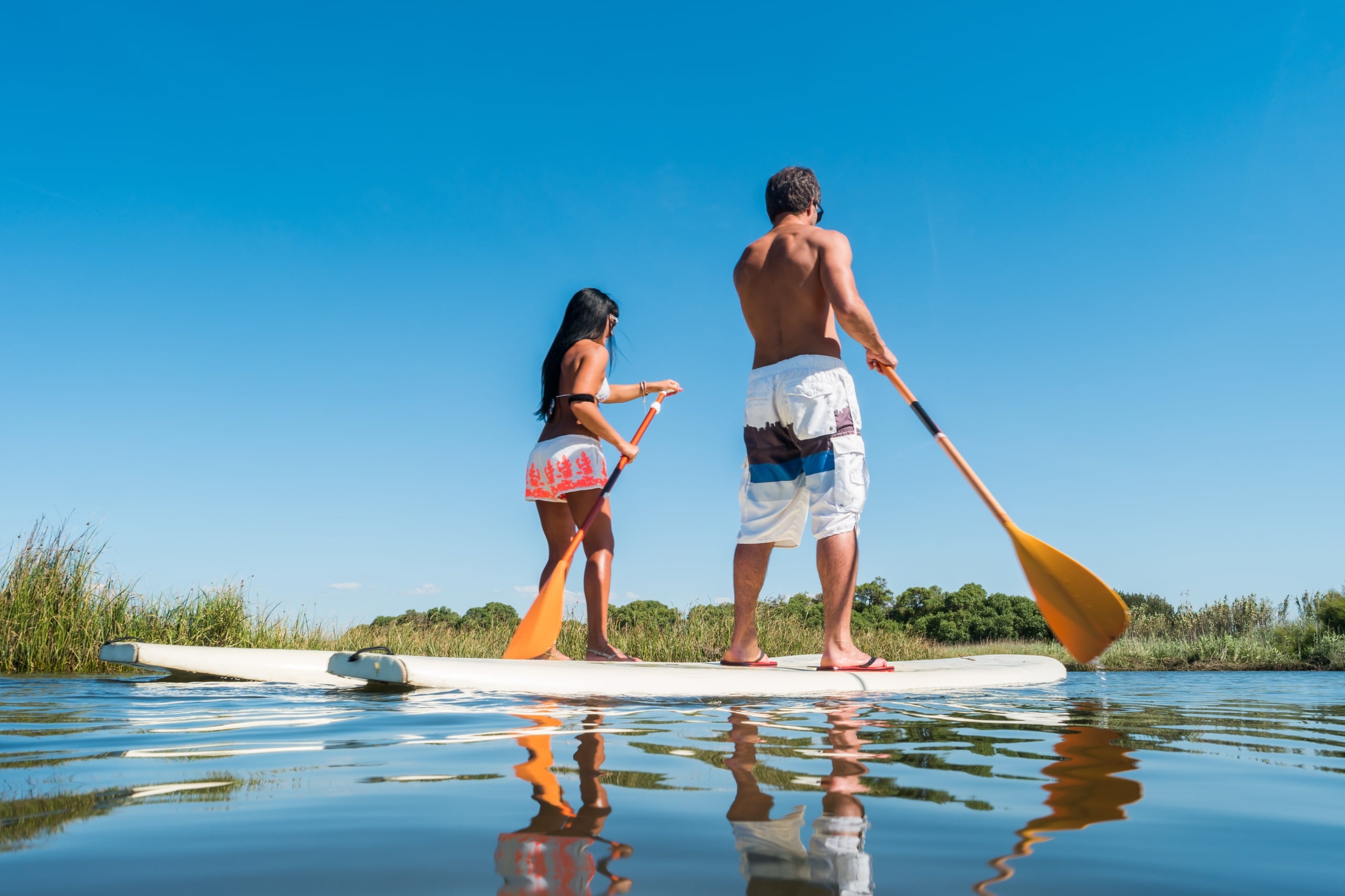 Man and woman stand up paddleboarding on Lake Minnetonka