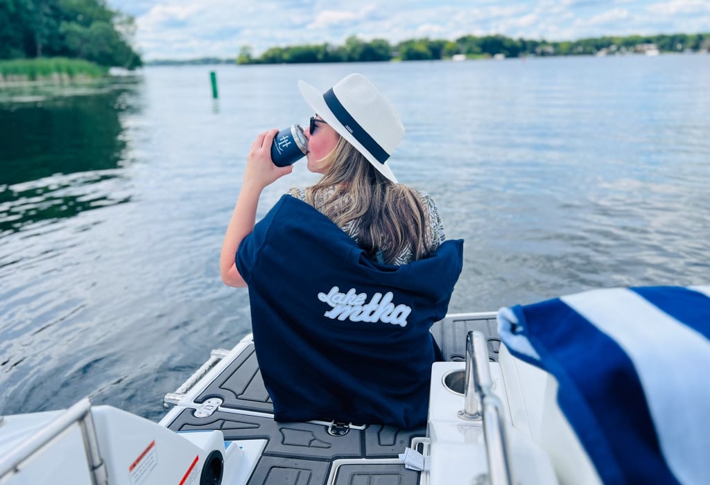 Girl on a dock sitting in a chair enjoying a drink