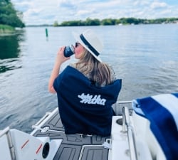 Girl on a dock sitting in a chair enjoying a drink