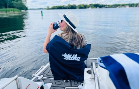 Girl on a dock sitting in a chair enjoying a drink
