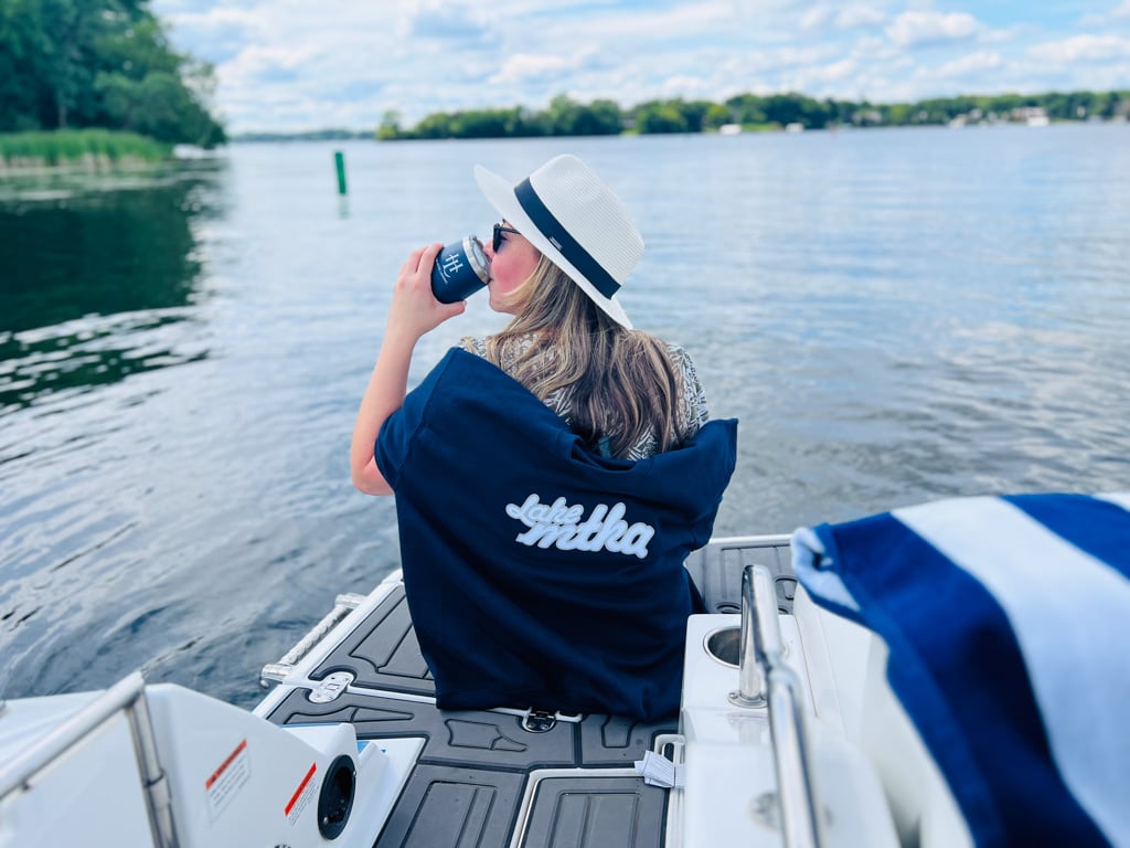 Girl on a dock sitting in a chair enjoying a drink