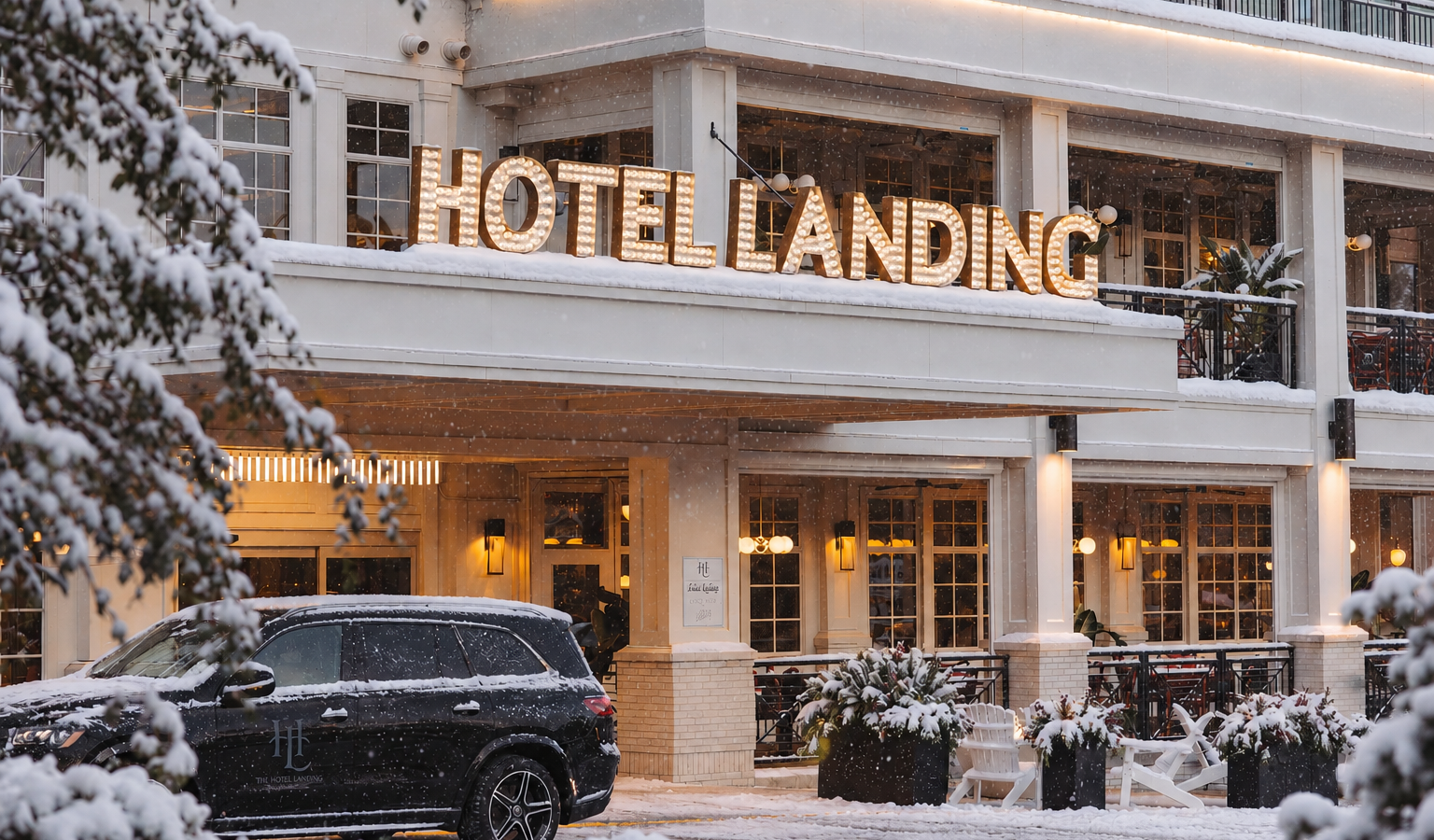 Snowy exterior of a hotel with a glowing 'HOTEL LANDING' sign, warm lights in the entrance, and a parked SUV in front.